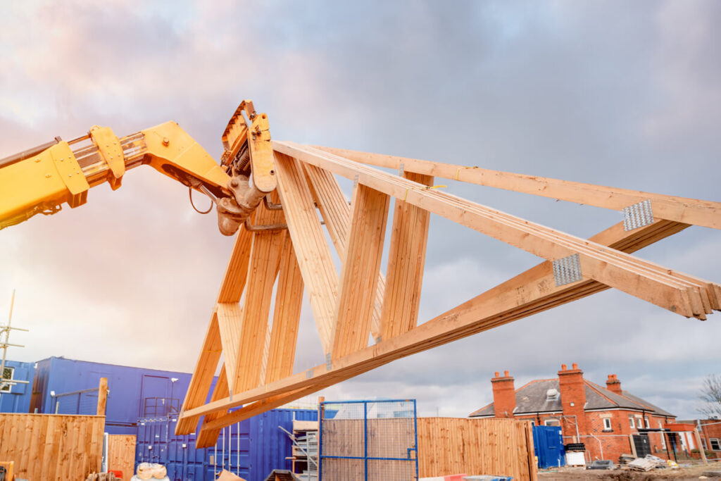 Roof trusses being carried by a forklift at a worksite